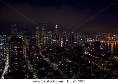 SEATTLE, WASHINGTON, USA - JAN 23rd, 2017: skyline of downtown Seattle, view from the top of the Space Needle during a cloudy night, city lights.