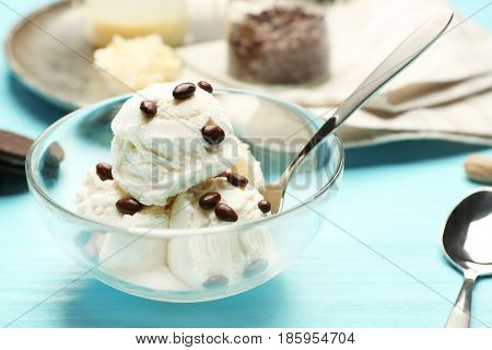 Delicious ice cream with chocolate candies on wooden table