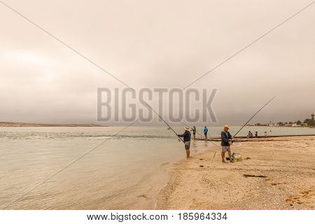 LANGEBAAN SOUTH AFRICA - MARCH 31 2017: Unidentified anglers at sunset at the Langebaan Lagoon on the Atlantic Coast of the Western Cape Province