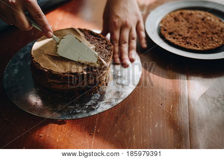 woman hands makeing cake on wooden background