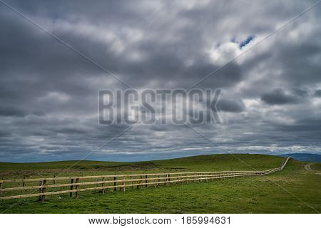 Long neverending wooden fence in the irish countryside, Ireland