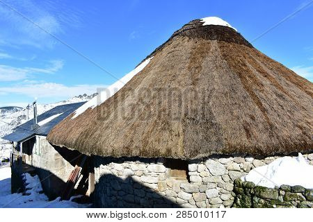 Ancient snowy palloza house made with stone and straw. Piornedo, Ancares, Galicia, Spain.