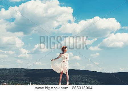 Girl On Sunny Blue Sky Background In Summer. Girl In White Summer Dress Pose On Blue Sky Abckground