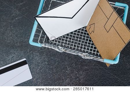 Shopping Cart With Cardboard Parcel Email Envelope And Payment Card On Concrete Desk, Concept Of Shi