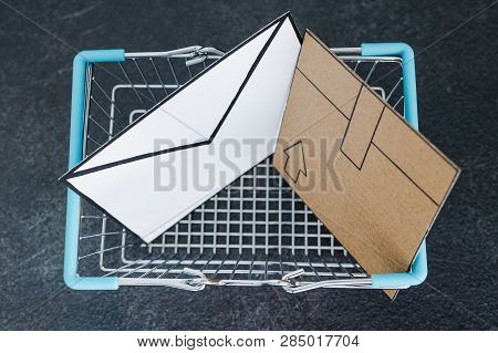 Shopping Cart With Cardboard Parcel And Email Envelope On Concrete Desk, Concept Of Shipping And Tra