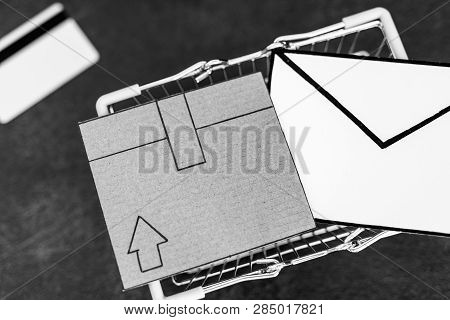 Shopping Cart With Cardboard Parcel Email Envelope And Payment Card On Concrete Desk, Concept Of Shi