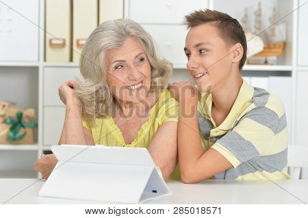 Portrait Of Grandson And Grandmother Using Tablert