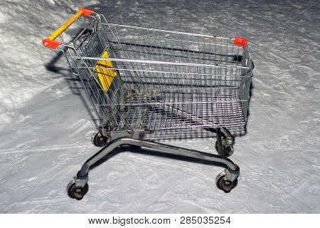 Left On The Parking Lot Of The Supermarket Trolley On The Snow
