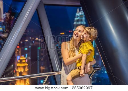 Mom And Son Are Looking At Kuala Lumpur Cityscape. Panoramic View Of Kuala Lumpur City Skyline Eveni