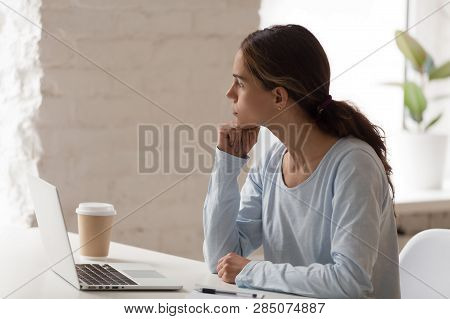 Concerned Female Sitting At Workplace Thinking Looking Away