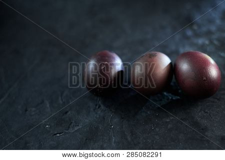 Dark Purple Eggs On A Rough Cement Background.