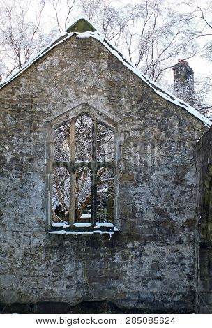 View Through A Window In The Wall Of A Medieval Ruined Church In Heptonstall Yorkshire With Snow Cov