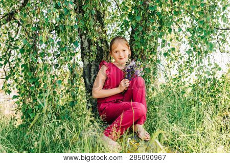 Summer Portrait Of Cute Little Girl Holding Small Bouquet Of Wild Flowers