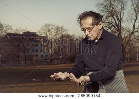 Man In Ugly Style Dress Practicing In Dowsing With Rods