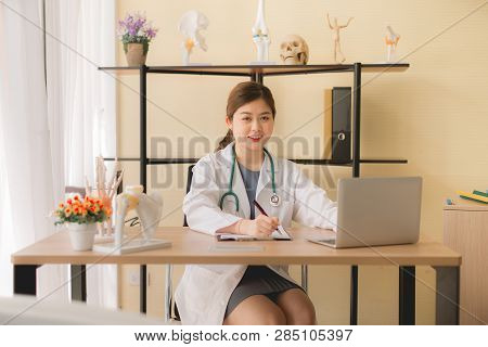 Doctor Beautiful Asian Women Sitting And Working On Desk Using Laptop And Writing Note At Hospital,f