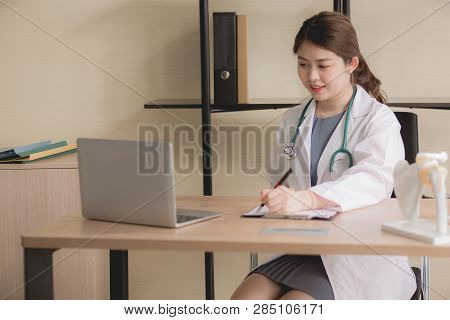 Doctor Beautiful Asian Women Sitting And Working On Desk Using Laptop And Writing Note At Hospital,f