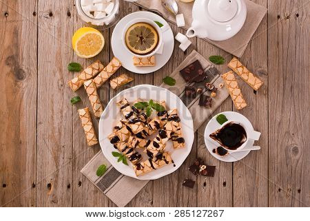 Puff Pastry Cookies With Chocolate Icing On White Dish.