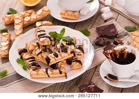 Puff Pastry Cookies With Chocolate Icing On White Dish.
