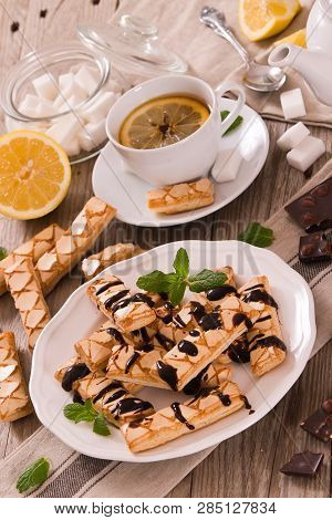 Puff Pastry Cookies With Chocolate Icing On White Dish.