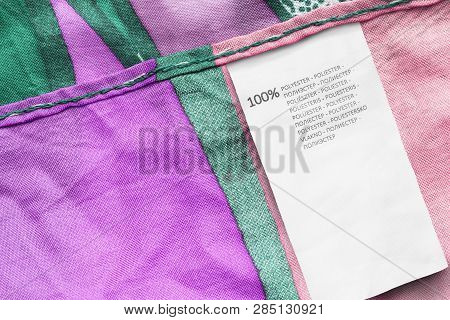 Clothes Label Says 100% Polyester In Different Languages On Colorful Textile Background
