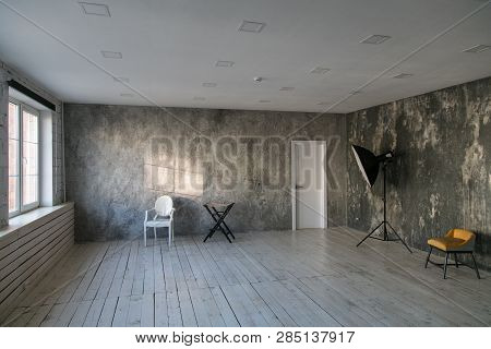 Modern Light Loft-style Room With Designer Chairs And Lighting. Gray Walls With The Texture Of The C