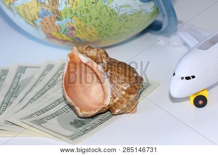 Planning A Trip Around The World. On Holiday With The Whole Family. In The Photo: Plane, Money, Shel