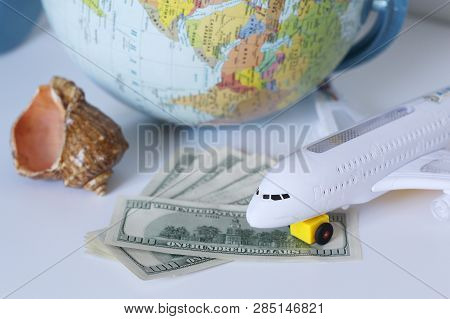 Planning A Trip Around The World. On Holiday With The Whole Family. In The Photo: Plane, Money, Shel