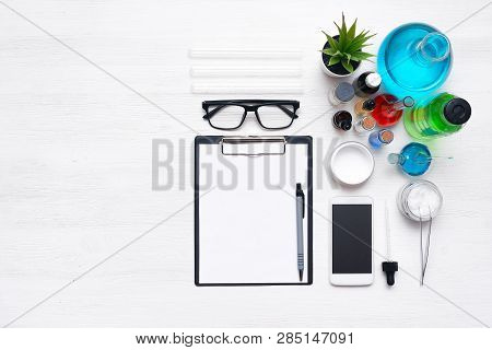 Laboratory Table With A Blank Paper Sheet Of Researching Results, Mobile Phone And A Chemical Reagen