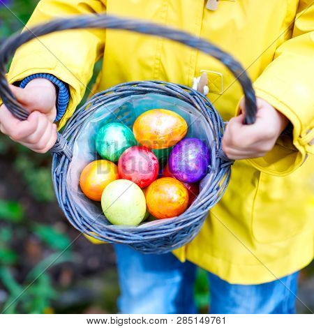 Close-up Of Hands Of Little Child With Colorful Easter Eggs In Basket. Kid Making An Egg Hunt. Child