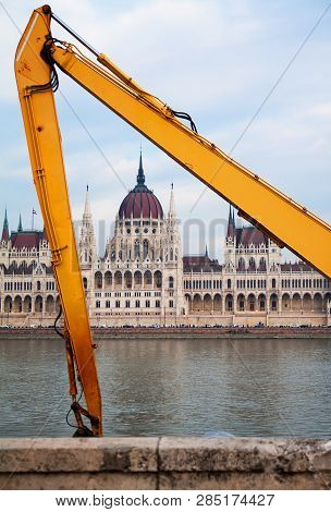 Parlament Building In Budapest Framed With Yellow Grabber Arms On River Danube.