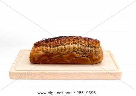 A Homemade Plumcake Standing On A Wooden Board With A White Background