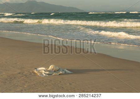 Plastic Garbage On The Beach In The Sea, Plastic Bag Pollutes The Sea