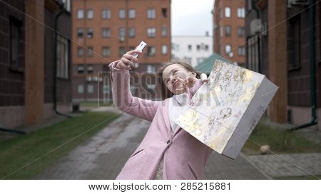 Young Happy Blonde Girl After Shopping Doing Selfie With Bright Packages