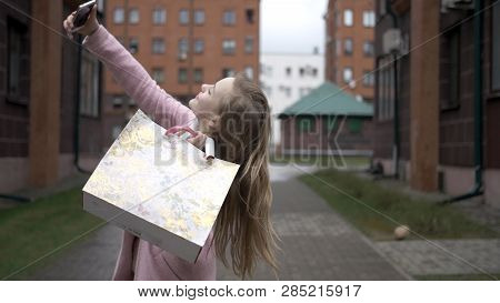 Young Happy Blonde Girl After Shopping Doing Selfie With Bright Packages