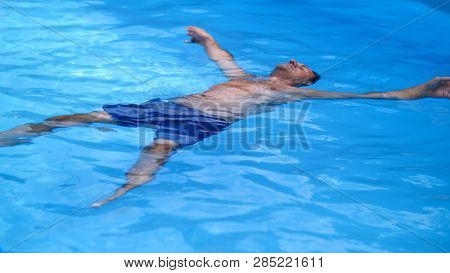 Man Lies On His Back In The Swimming Pool, Relaxes