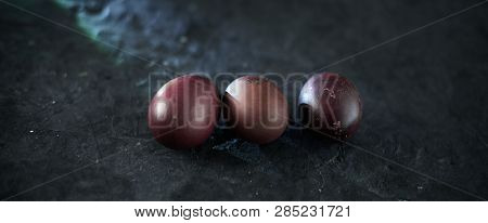 Dark Purple Eggs On A Rough Cement Background.