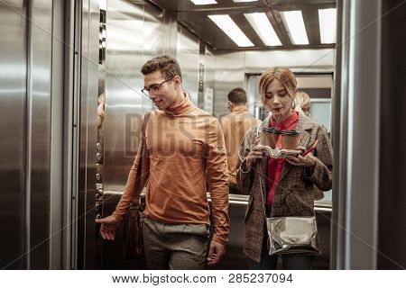 Wife Sipping Cappuccino While Taking Elevator With Her Man