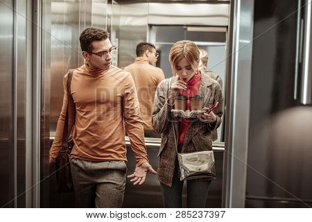 Slim Blonde-haired Girlfriend Drinking Coffee In The Elevator