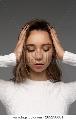 Beautiful Portrait Of Young Model Touch Her Hair Both Of Arms And Look Down