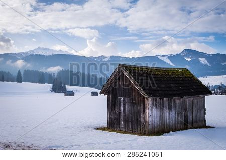 Old Wooden Hut Near Bad Mitterndorf With Snow Covered Mountain Kammspitz On A Cloudy Day In Winter I