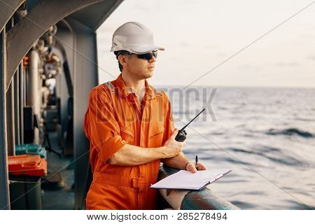 Deck Officer On Deck Of Offshore Vessel Holds Vhf Walkie-talkie Radio