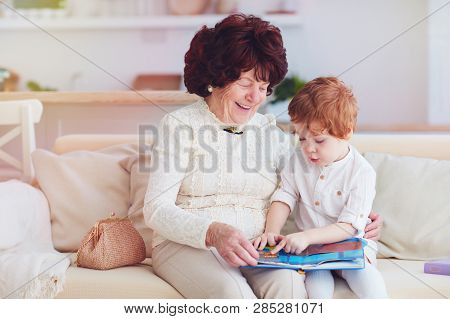 Portrait Of Beautiful Mature Woman (80 Years Old) With Her Great-grandson At Home, Reading Education