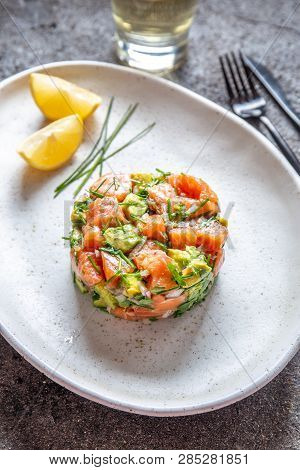 Peruvian Food. Salmon Ceviche With Avocado, Spring Onion And Lemon On White Plate Served With White 