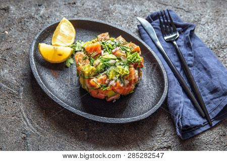 Peruvian Nikkei Food. Salmon Avocado Ceviche On Black Plate, Black Background Top View