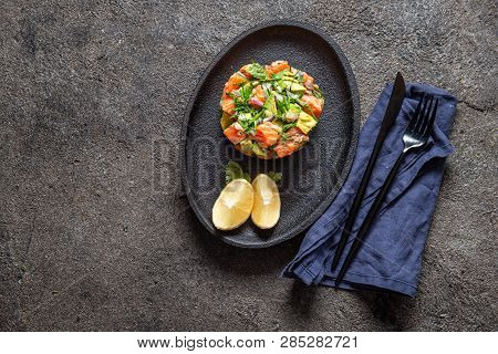 Peruvian Nikkei Food. Salmon Avocado Ceviche On Black Plate, Black Background Top View