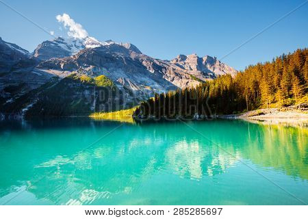 Idyllic view of the azure lake Oeschinensee. Location place European Alps, Kandersteg, Bernese Oberland, Switzerland, Europe. Scenic image of popular tourist attraction. Discover the beauty of earth.