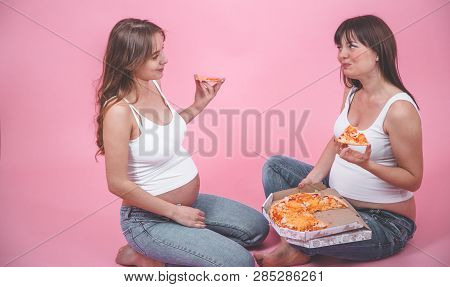 Nutrition Concept, Pregnant Women Eating Pizza On A Pink Background