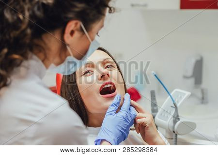 Young Woman Sitting In A Dental Chair For Appointment Of A Doctor. During This Time, She Was Very Wo
