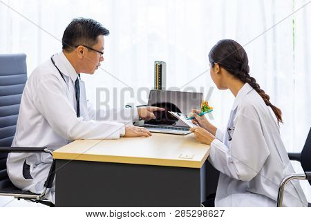 Two doctors in the hospital discuss the diagnos of the patient
