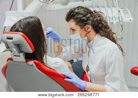 Young Woman Sitting In A Dental Chair For Appointment Of A Doctor. During This Time, She Was Very Wo